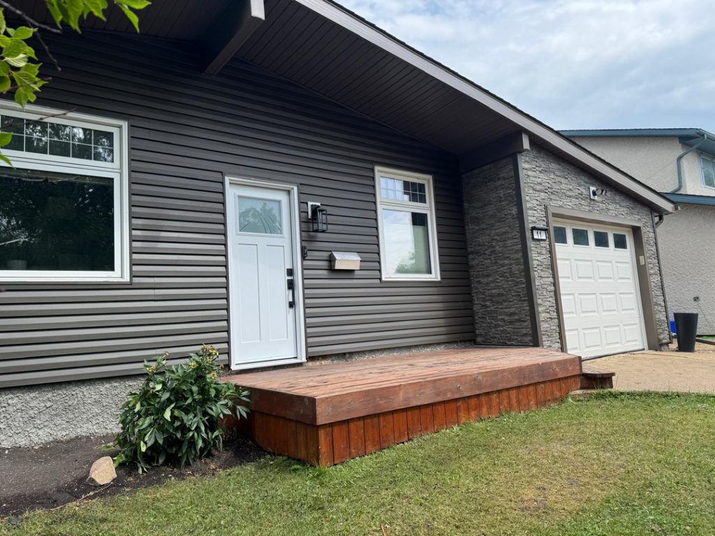 Modern home renovation contractor winnipeg gray siding white door garage stone accents 4dbcffa5 68ce 43e9 a01a 685587189f16